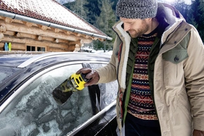 Eine Person benutzt einen Kärcher Eiskratzer